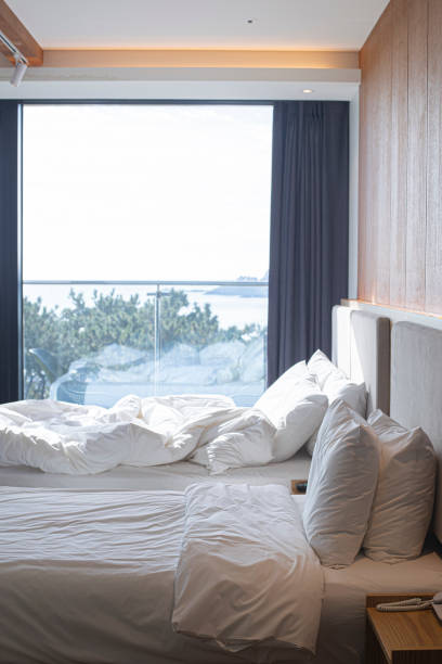 istock Empty bed in modern hotel room at sunrise. 2094298091