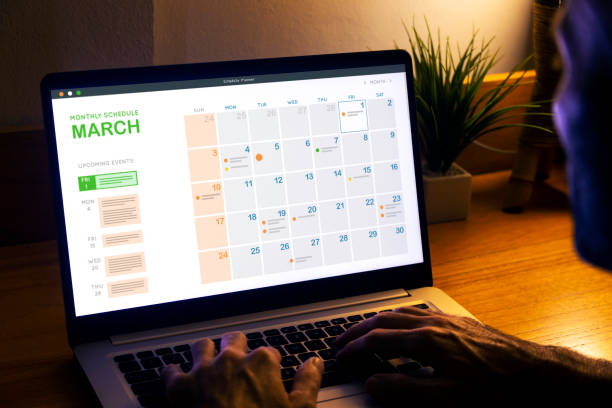 istock Monthly planner schedule. Man looking at digital calendar on laptop screen, at night to plan the next day. 2094314073
