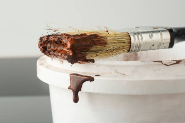 istock Drops of brown paint flow down from a brush. 2094325321