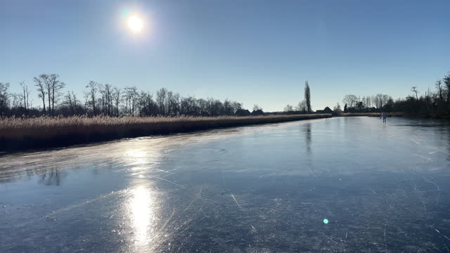 Ice skating on a frozen lake in the Weerribben Wieden nature reserve