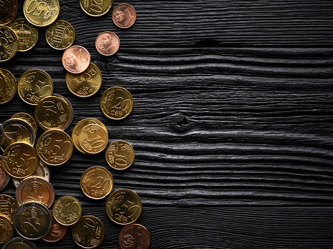 Money finance background with euro coins over black wooden background