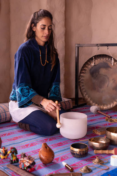 istock A beautiful Latina woman with a joyful and calm expression, gently playing a quartz singing bowl. 2094382867