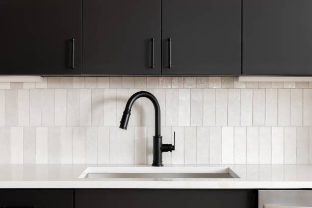 istock A kitchen faucet detail with black cabinets and subway tile backsplash. 2094383402