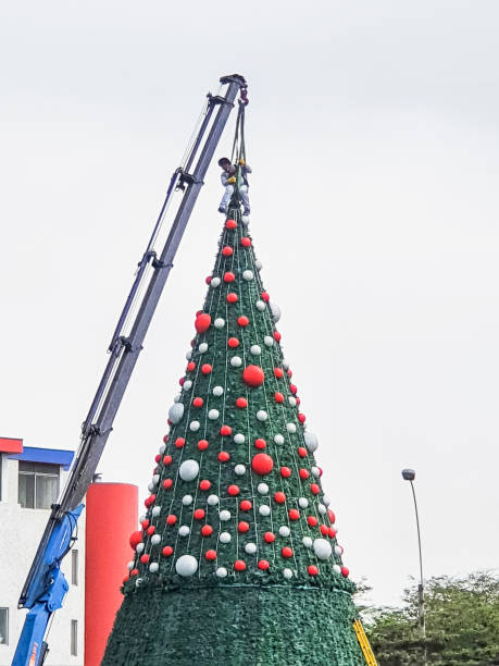 istock Man on crane decorating big Christmas tree in the city. 2094398315