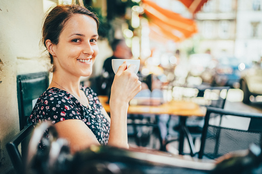 Tourist drinking coffee at sidewalk cafe in Krakow