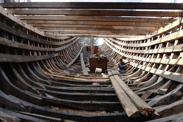 Welding new steel plates on a ship's hull during repair work on a ship in a dry dock.