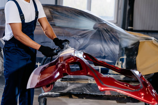istock Unrecognizable mechanic using grinding unit on red bumper at automobile repair and renew service station. 2094440738