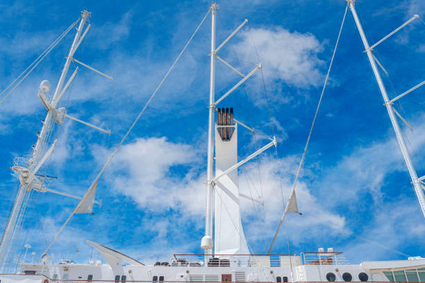 White sailing ship with lowered sails in the port.
