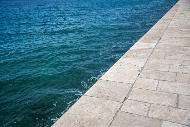 Line of stone embankment and sea.