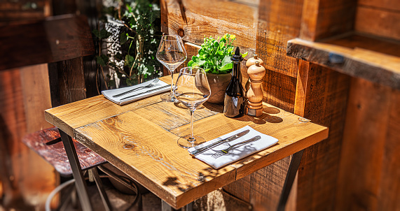 Table in the restaurant in the open air with glasses of wine and serving.