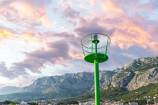 Small green metal lighthouse on the waterfront.