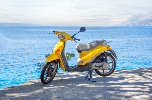Yellow brand-less moped on the beach on a summer day. Croatia