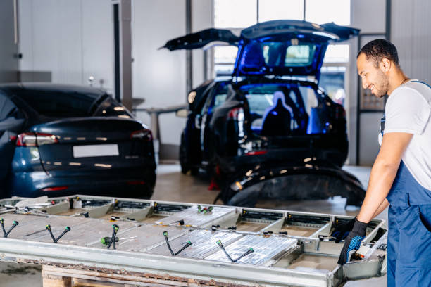 istock Positive smiling arabian male technician engages with an EV Car Battery Cell Module in auto service. Maintenance car battery repair. 2094458118