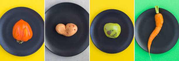 istock Collage of ugly fruit and vegetable on the black plate. Top view. Close-up. 2094458652