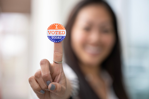 USA president election day concept. Thumb up gesture and inscription vote on blue background