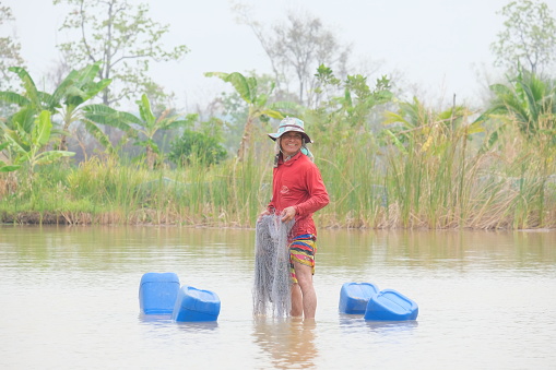 mid adult woman selling fish at fish market in Hoi An in Vietnam in the early morning