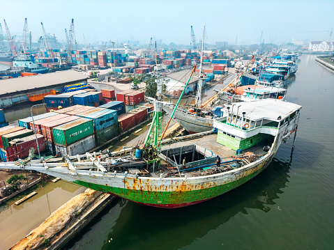 Drone shot of colorful wooden boats docked at Sunda Kelapa, the old port of Jakarta on the estuary of the Ciliwung River, Indonesia.