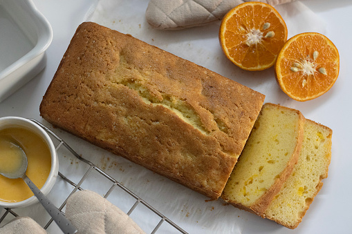 Sliced Loaf of Orange pound cake, also known as citrus loaf cake or orange butter cake. Moist, flavorful dessert, with zesty glaze perfect for food lovers, baking enthusiasts, and for sweet cravings