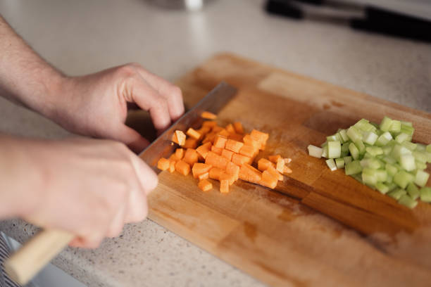 istock Close-up of hands chopping vegetables on a cutting board 2094523186