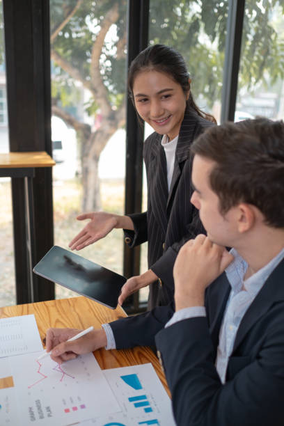 istock Two business people using a laptop in an office, a man and a women analyzing documents stat at office 2094524838