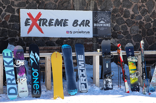 Bright, varied snowboards stand in front of the entrance to the cafe. Ski resort in Elbrus region, Kabardino-Balkaria, Russia. Mir station
