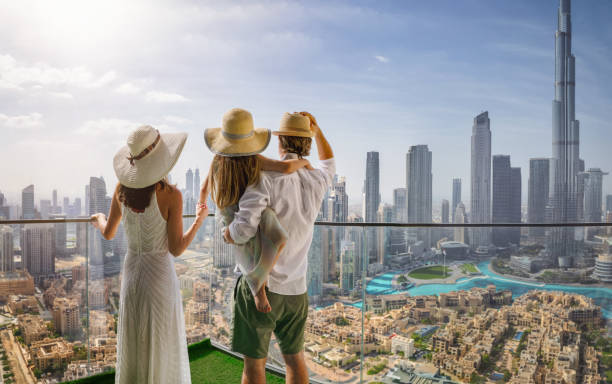 A family on a city break enjoys the view over the skyline of Dubai A elegant family on a city break vacation enjoys the panoramic view over the skyline of Dubai, UAE travel hotel accommodations stock pictures, royalty-free photos & images