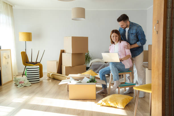 istock Happy couple using laptop in new apartment 2094540422
