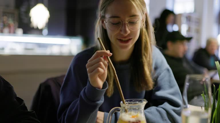 Teenager girl enjoying lemonade while waiting for the order in restaurant