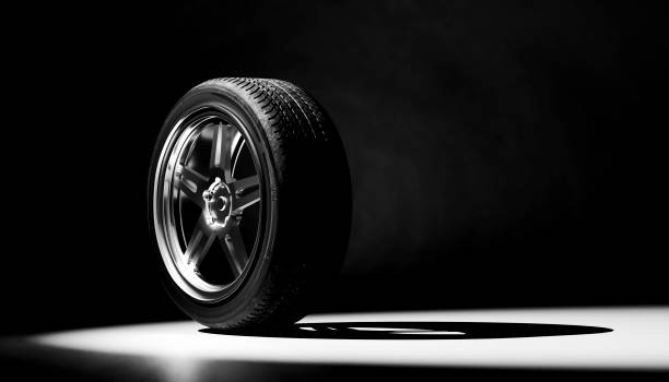 side view of a cart wheel in a black and white three-dimensional image with a shadow on the ground