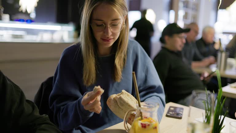 Teenager girl enjoying lemonade while waiting for the order in restaurant