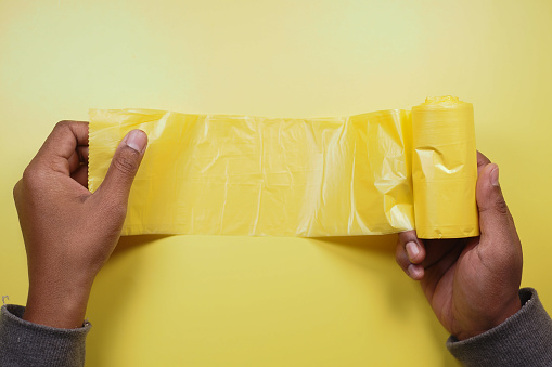 top view of holding a yellow color trash bag