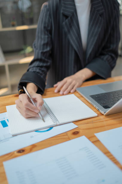 istock Closed up young business man read write doing report figure paper chart, professional accountant calculating annual balance cash flow money report finance at office 2094574072