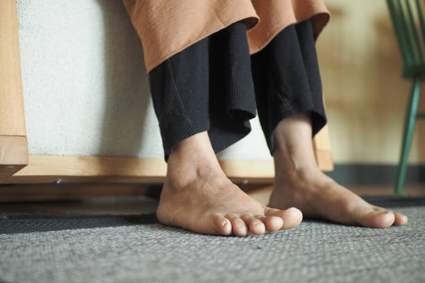 istock Woman sitting on sofa with feet on carpet at home. 2094575723