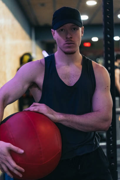 istock A muscular redhead athlete holds a weight ball, looking serious at camera. 2094587035