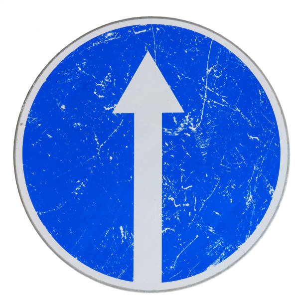 istock Old blue round road sign with a white arrow. The surface is scratched and worn. Background. Detail. 2094599784