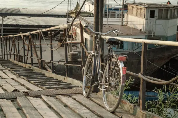 Old bicycle leaning against dock railing
