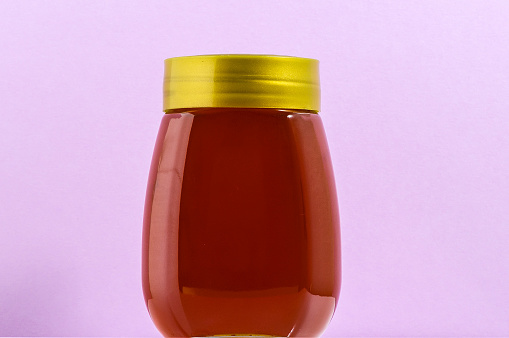 One Full Honey Jar on a Colored Background