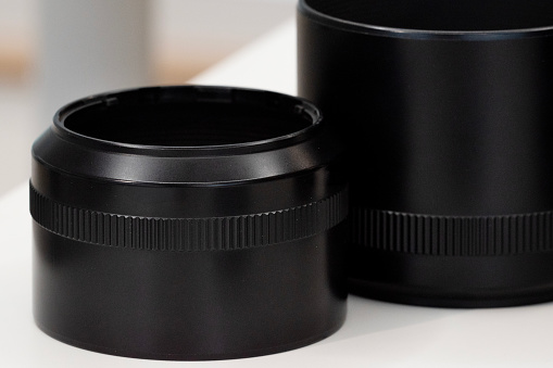 Close up of camera lens and photography equipment on a wooden table.