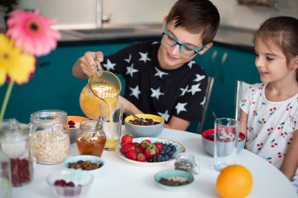 istock Smiling children preparing a healthy breakfast at home 2094686580