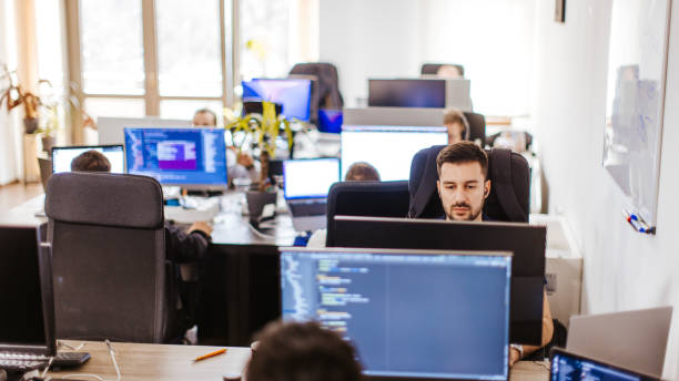 istock Male Caucasian developer working on a computer at the open space office with coworkers 2094689233