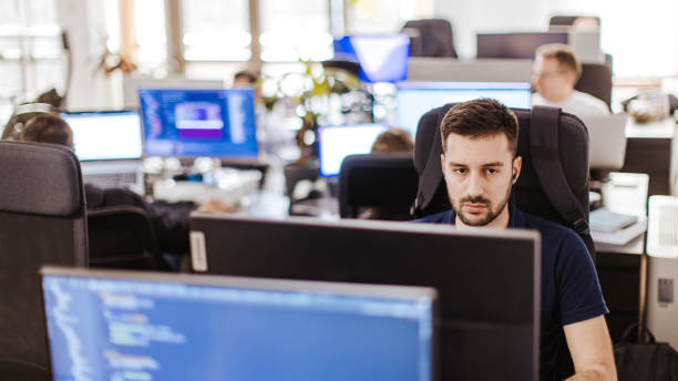 istock Male Caucasian developer working on a computer at the open space office with coworkers 2094689234