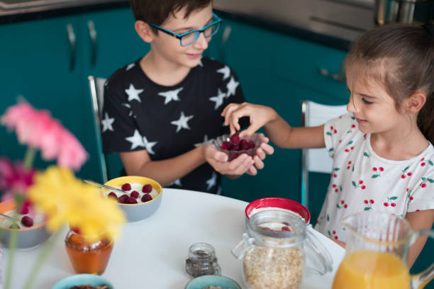 Brother and sister preparing a healthy breakfast at home.