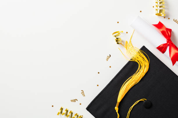 istock Graduation cap, diploma and glitter confetti on white background. 2094693594