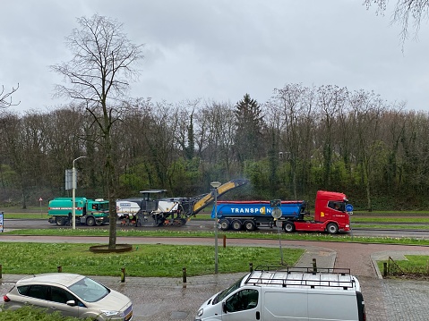 Brunssum, Netherlands - March 18,  2024.  Contractor bussy with replace the asphalt on an urban road in the city.