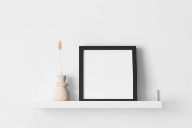 istock Black square frame mockup with a lagurus decoration on the wall shelf. 2094699006