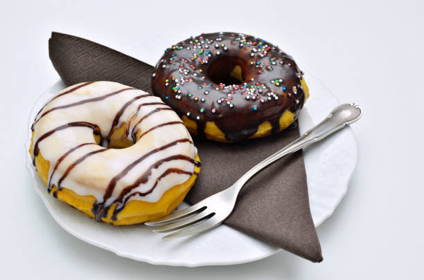 Glazed Donut and Chocolate Donut with Sugar sprinkles on white Plate stock photo