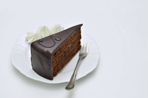 Piece of Sacher torte with Whipped cream on white Plate stock photo