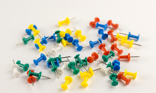 A pile of colourful pins on a white background. A set of pins