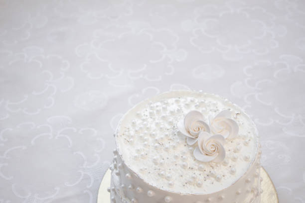 White party cake with white icing and pearls, cake design. Handmade cake made for a special celebratory occasion.