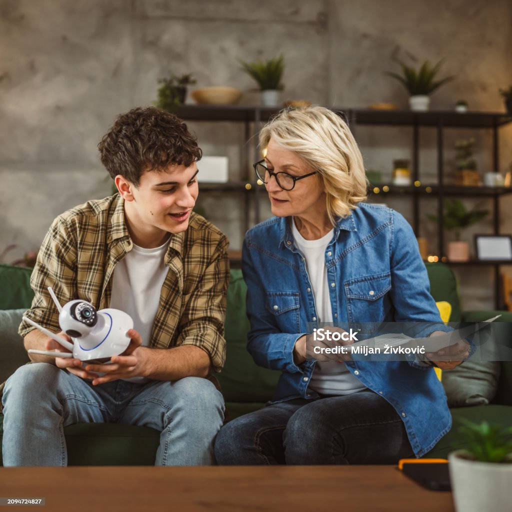 Mother And Son Adjust And Install Home Cctv Video Surveillance Camera